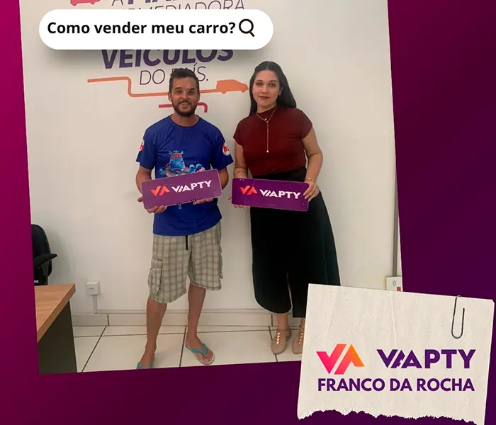 Casal de clientes segurando a placa da Vaapty na unidade de Franco da Rocha